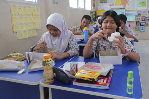 Sejumlah siswa menyantap makanan saat simulasi program Makan Siang Bergizi Gratis di sekolah wilayah Lanud Halim Perdanakusuma di SDS Angkasa 5 Lanud Halim Perdanakusuma, Jakarta, Selasa (26/11/2024). Foto: Ist