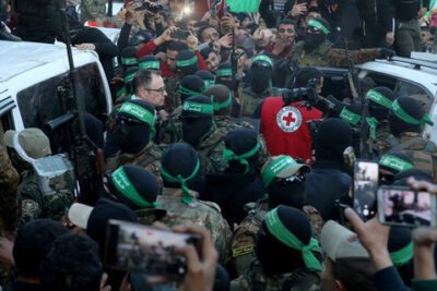Militan Hamas Palestina berkumpul selama serah terima sandera yang diculik selama serangan 7 Oktober 2023 di Israel oleh Hamas kepada anggota Komite Palang Merah Internasional (ICRC) di Kota Gaza, Minggu (19/1/2025). Foto: REUTERS