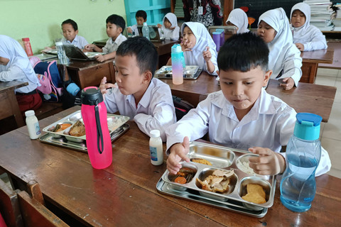 Murid menikmati paket makan program Makan Bergizi Gratis (MBG) di SD Sinduadi Timur, Kapanewon Mlati, Kabupaten Sleman, Senin (13/1/2025). Foto: Ist