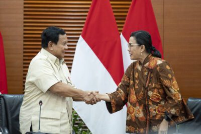 Presiden Prabowo Subianto (kiri) berjabat tangan dengan Menteri Keuangan Sri Mulyani (kanan) usai menyampaikan keterangan pers terkait kenaikan tarif Pajak Pertambahan Nilai (PPN) di Kantor Kementerian Keuangan, Jakarta, Selasa (31/12/2024). Foto: Ist