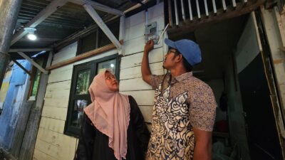 Ferra (kiri) dan suaminya, Taufik (kanan) kini dapat merasakan listrik sendiri semenjak menerima bantuan penyambungan listrik gratis program Light Up The Dream yang berasal dari donasi pegawai PLN.