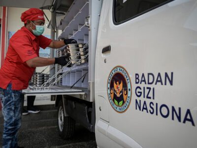 Petugas menyiapkan makanan ke dalam mobil untuk didistribusikan ke sekolah untuk program Makan Bergizi Gratis (MBG). Foto: ANTARA 