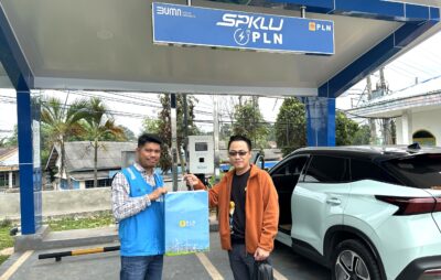 Manager ULP Bumi Abung, Henri Sinaga berfoto bersama pemudik asal Jakarta, Des Chandra Kusuma pengguna SPKLU PLN UP3 Kotabumi