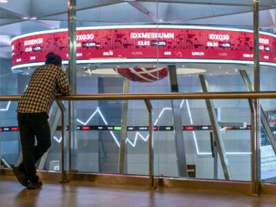 Warga memantau pergerakan saham di Bursa Efek Indonesia, Jakarta, Selasa (18/3/2025). Foto: AFP