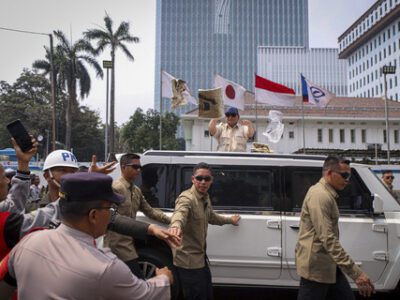 Presiden Republik Indonesia Prabowo Subianto membagikan kaos dari Mobil Maung saat meninggalkan perayaan May Day di kawasan Monas, Jakarta, Kamis (1/5/2025). Foto: kumparan