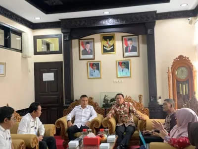 Dalam upaya untuk memastikan efektivitas pemerintahan dan program di tingkat Kabupaten, Bupati Lampung Barat Parosil Mabsus melakukan kunjungan kerja (KunKer) ke Kabupaten Jembrana Provinsi Bali. Kunjungan Parosil Mabsus beserta rombongan pada (30/07) disambut langsung oleh Wakil Bupati Jembrana, IGN Patriana Krisna (Ipat) beserta Kepala OPD terkait. Bupati Lampung Barat Parosil Mabsus menjelaskan, kunjungannya beserta jajaran merupakan bentuk silaturahmi sekaligus upaya membangun sinergi antardaerah. “Kunjungan ini bukan hanya silaturahmi, tapi juga bagian dari komitmen kami untuk memperkuat kerja sama dan mempelajari praktik-praktik baik yang telah diterapkan di Kabupaten Jembrana,” ungkap Parosil Mabsus, Kamis 31 Juli 2025. Ia mengatakan, kunjunganya ke Jembrana bukan merupakan untuk yang pertama kalinya “Saat dulu saya masih menjadi anggota DPRD, saya pernah berkunjung ke sini (Jembrana) dan sangat tertarik dengan program sekolah gratis. Hari ini saya ingin melihat bagaimana kelanjutan dari program itu,” jelas Parosil Mabsus. Berdasarkan dialognya dengan Patriana Krisna, Parosil Mabsus mengapresiasi keberlanjutan dan konsistensi Pemerintah Kabupaten Jembrana dalam menjalankan program-program yang berpihak pada masyarakat, seperti sekolah gratis, pengelolaan BLUD di puskesmas, hingga pembangunan Puskesmas Pembantu (Pustu) di setiap Pekon (Desa). Dengan kunjungan tersebut, Pak Cik begitu sapaan Akrabnya bagi bupati dua periode itu, berharap langkah ini menjadi awal untuk memperkuat sinergi antardaerah dalam rangka peningkatan pelayanan publik, khususnya di sektor pendidikan dan kesehatan. Pak Cik mengaku, ada banyak hal yang dapat di pelajari oleh pihaknya dari pertemuan tersebut “Nanti akan kami kaji bersama tim di Lampung Barat, mana program yang bisa segera diimplementasikan, dan mana yang perlu dikomunikasikan lebih lanjut untuk disesuaikan dengan kondisi daerah kami,” pungkas Parosil Mabsus. Sementara, Wabup Jembrana, IGN Patriana Krisna menyampaikan apresiasi dan terima kasih atas kunjungan dari pemerintah kabupaten Lampung Barat. Patriana mengaku, pertemuan tersebut menjadi momen yang sangat membanggakan karena menunjukkan adanya perhatian dan keinginan untuk saling berbagi praktik baik antar pemerintah daerah. “Dari diskusi tadi, kami membagikan berbagai informasi, termasuk program sekolah gratis dan pengelolaan layanan kesehatan melalui BLUD di puskesmas,” ujarnya. Ia yakin ada beberapa hal yang bisa diadopsi atau menjadi referensi untuk Pemerintah Kabupaten Lampung Barat ke depannya.