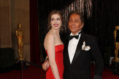 Aktris dan pembawa acara Oscar, Anne Hathaway, dan perancang busana Valentino tiba di karpet merah untuk Academy Awards ke-83 yang diadakan di Kodak Theatre di Hollywood, California (27/2/2011). Foto: Valerie Macon/AFP