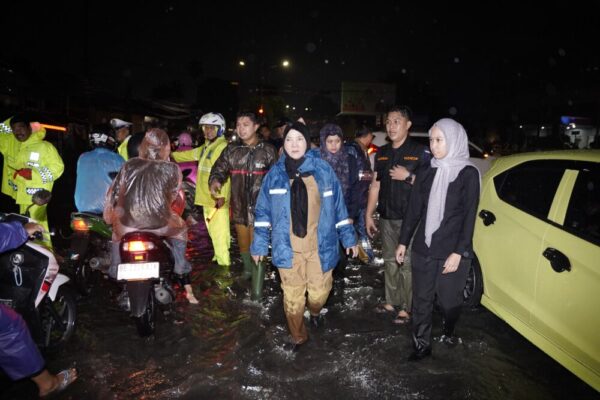 Bandar Lampung – Hujan deras yang mengguyur Kota Bandar Lampung pada Selasa (14/4) sore hingga malam menyebabkan sejumlah wilayah terdampak banjir akibat meluapnya sungai dan gorong-gorong. Merespons kondisi tersebut, Wali Kota Bandar Lampung, Eva Dwiana, langsung turun ke lapangan untuk memantau kondisi warga, khususnya di wilayah Kecamatan Tanjungkarang Pusat. Berdasarkan pantauan, hujan yang terjadi sejak pukul 18.00 WIB hingga 23.00 WIB mengakibatkan genangan air di sejumlah titik, termasuk di Kelurahan Penengahan. Dalam penanganannya, Pemerintah Kota Bandar Lampung langsung mengerahkan satgas gabungan untuk membantu warga terdampak. Selain itu, lampu penerangan yang sempat padam akibat hujan juga berhasil dipulihkan dalam waktu singkat. Tim dari Badan Penanggulangan Bencana Daerah (BPBD) turut diturunkan untuk melakukan pengerukan sedimentasi di gorong-gorong serta penyedotan air agar aliran kembali lancar. Langkah cepat tersebut mendapat apresiasi dari warga. Bayu (34) mengaku terbantu dengan respons sigap pemerintah. “Lampu yang sempat mati sudah kembali hidup, ini sangat membantu aktivitas warga,” ujarnya. Hal senada disampaikan Amin (44) yang menyebut genangan air cepat surut karena rutin dilakukan pembersihan saluran air. “Air dari gorong-gorong cepat turun karena sering dibersihkan,” katanya. Pemerintah Kota Bandar Lampung diketahui terus melakukan percepatan normalisasi sungai dan gorong-gorong di berbagai wilayah, termasuk penataan konstruksi bangunan di Kelurahan Tanjung Senang. Wali Kota Eva Dwiana menegaskan bahwa langkah tersebut merupakan bagian dari komitmen pemerintah dalam memberikan solusi jangka panjang terhadap persoalan banjir yang kerap terjadi. “Normalisasi sungai tetap menjadi prioritas, terutama pembersihan sedimentasi di setiap gorong-gorong,” tegasnya. Dengan upaya tersebut, Pemerintah Kota Bandar Lampung berharap risiko banjir dapat diminimalisir serta memberikan rasa aman dan nyaman bagi masyarakat.